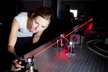 Femme scientifique faisant des recherches dans un laboratoire d'optique quantique
